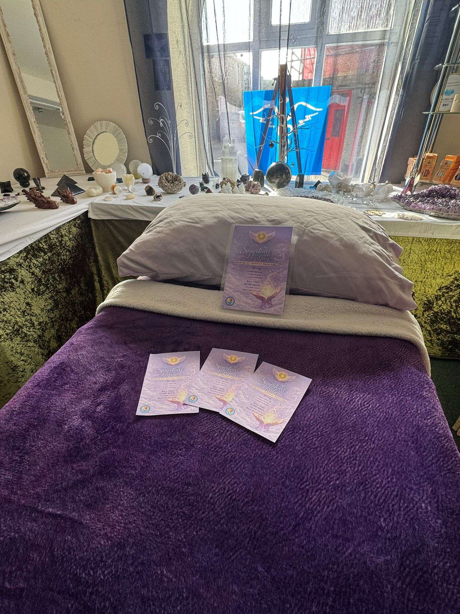 The comfortable treatment bed with crystals and Kerry's purple brochures